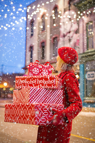 Woman holding presents in snow